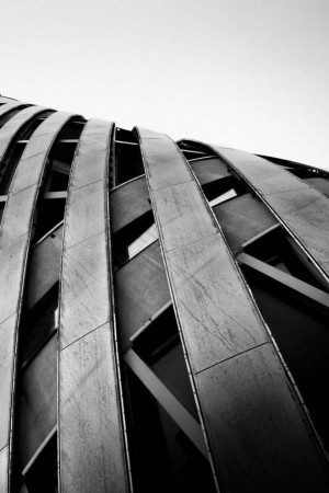 Black and white photograph of a modern building's curved facade.