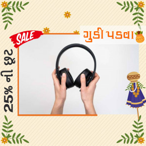 Hands holding black headphones with a sale banner and festive decorations