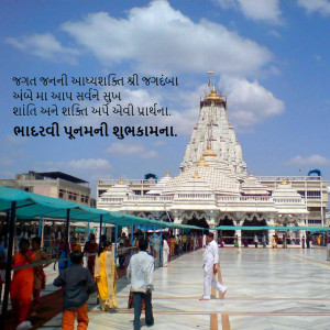 Exterior view of a white Swaminarayan temple with people in the foreground and a blue sky with clouds.