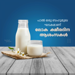 A glass bottle and a glass of milk with flowers on a wooden surface.