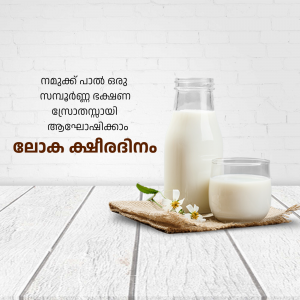 A bottle and glass of milk on a wooden surface with flowers