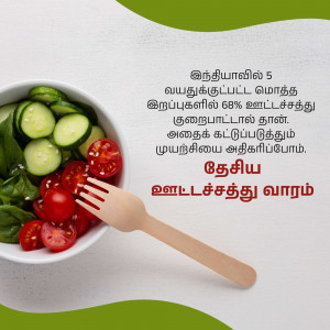 A bowl of fresh salad with cucumbers, tomatoes, and spinach, with a wooden fork.