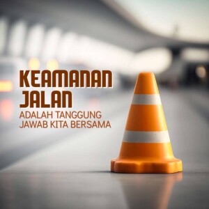 Orange traffic cone with text in Indonesian about road safety