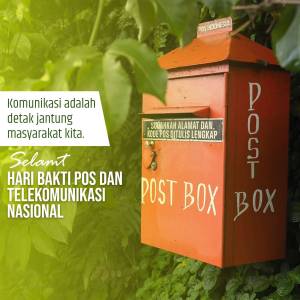 A vibrant red Indonesian post box with white lettering, surrounded by lush green foliage.