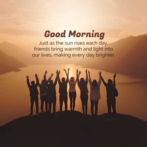 Silhouetted group of friends raising their arms towards a sunrise over a mountain and lake.