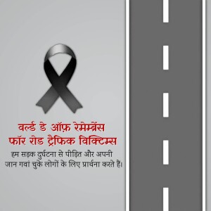 A road with a black ribbon and text in Hindi commemorating road traffic victims.