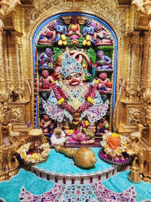 Close-up of a beautifully decorated Hanuman idol in a temple setting.