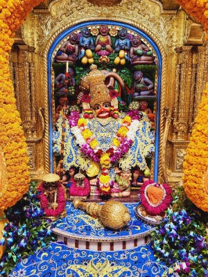 Close-up of a beautifully decorated Hanuman idol in a temple setting.