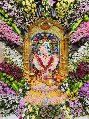 Image of Hanuman Ji idol adorned with vibrant flowers and decorations.