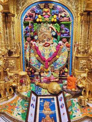 Close-up of a beautifully decorated Hanuman idol in a temple setting.