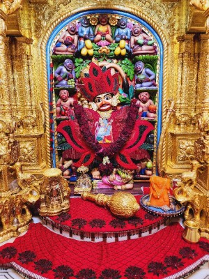 Close-up of a beautifully decorated Hanuman idol within a temple setting.