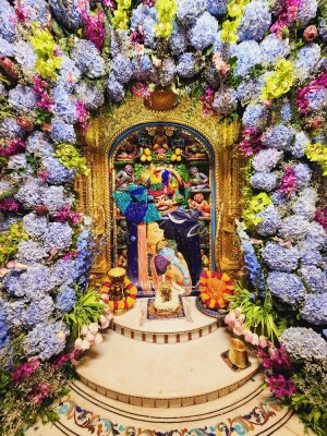 Hanuman idol adorned with vibrant flowers in a temple setting