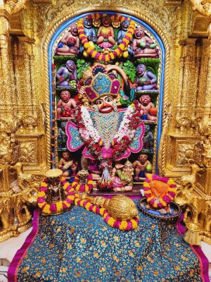Close-up of a beautifully decorated Hanuman idol in a temple setting.