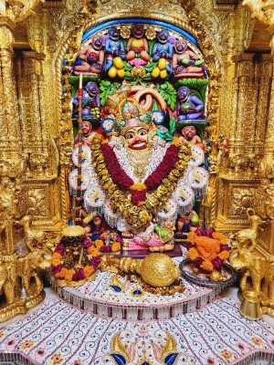 Golden idol of Lord Hanuman adorned with flowers and jewelry