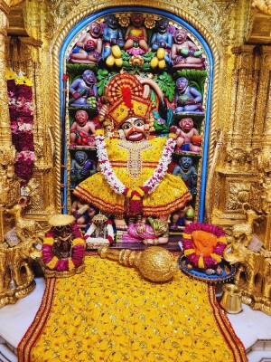 Close-up of a beautifully decorated Hanuman idol in a temple setting.
