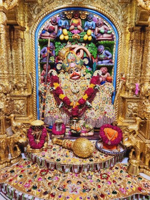 Ornate golden idol of Lord Hanuman adorned with flowers and offerings