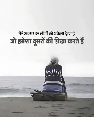 A lone figure sits on a beach looking out at the ocean with text in Hindi about loneliness.