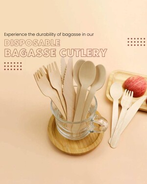 A glass jar filled with disposable cutlery made from bagasse, placed on a wooden coaster with apples nearby.