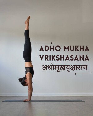 Woman performing the Adho Mukha Vrikshasana yoga pose, also known as Handstand.