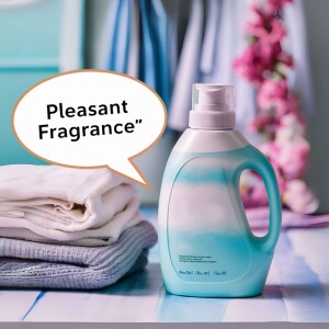 Bottle of laundry detergent with folded clothes and flowers