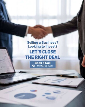 Handshake over a laptop and business charts, representing a successful business deal.