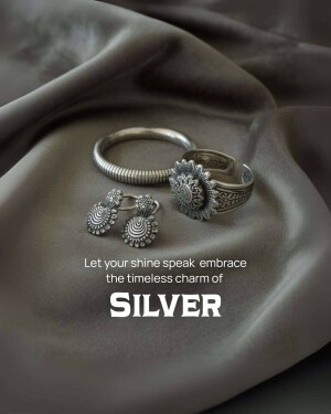 Close-up of silver bracelets, rings, and earrings on a gray fabric background.