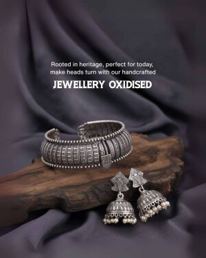 Close-up of an oxidized silver bracelet and earrings on a wooden surface