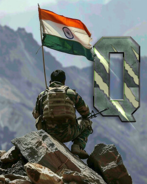 Indian soldier standing guard with the Indian flag waving in the background.