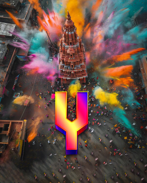 Aerial view of a temple during Holi festival with a large letter Y in the foreground