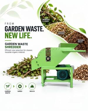 Green garden waste shredder machine turning branches and leaves into mulch