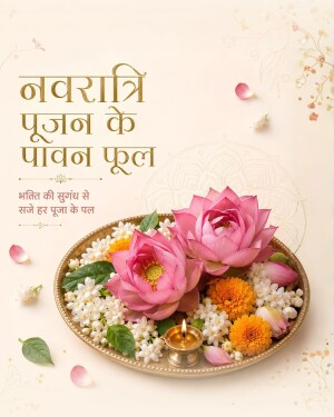 A brass plate decorated with pink lotus flowers, marigolds, jasmine, and a lit diya lamp for Navratri puja.