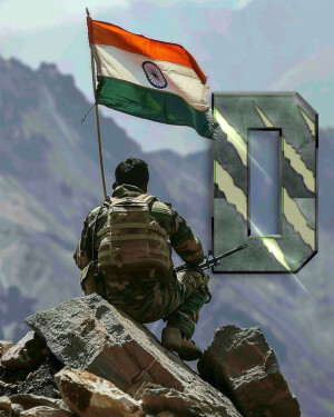 Indian soldier standing guard with the Indian flag waving in the background, mountains in the distance.
