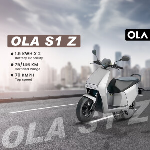 Side view of a white Ola S1 Z electric scooter on a road with city background